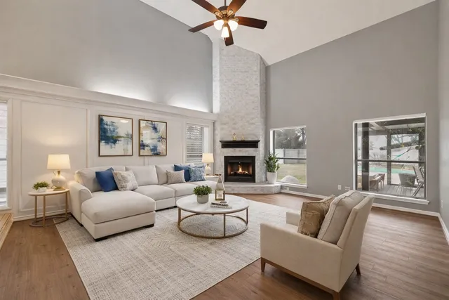 a living room with furniture a fireplace and a large window