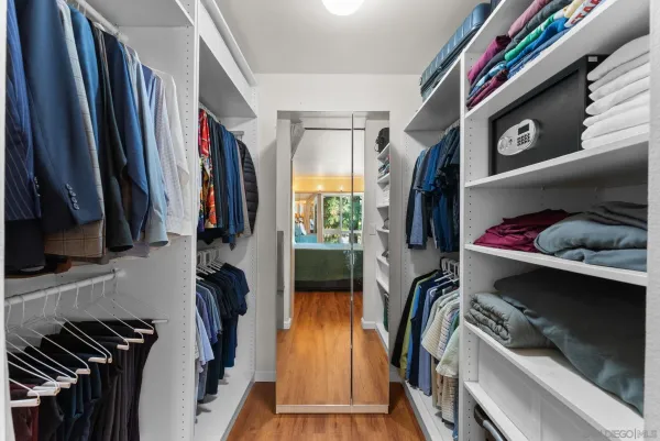a view of walk in closet with clothes and shoes