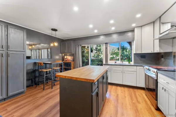 a kitchen with stainless steel appliances kitchen island granite countertop a stove a sink and a refrigerator
