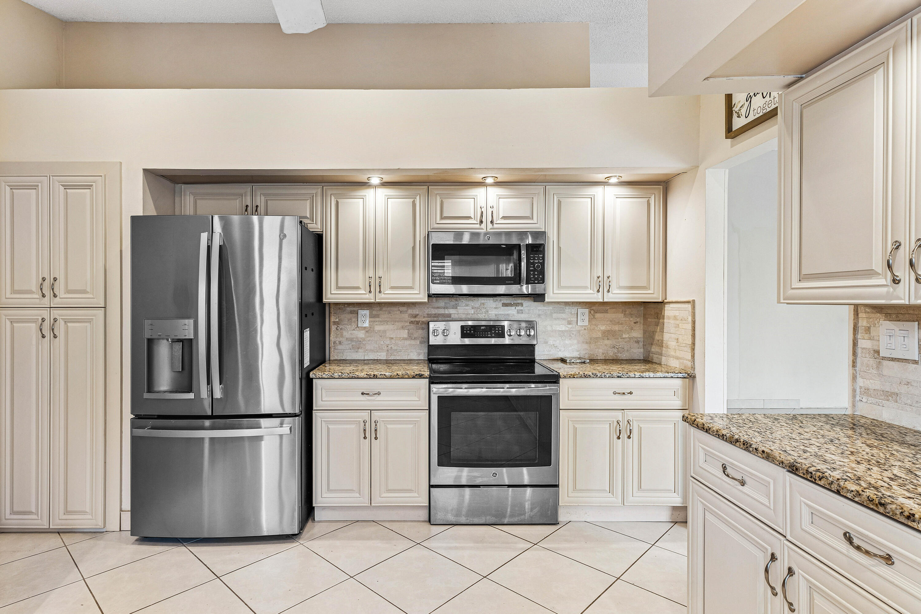6249 Beaconwood Road Lake Worth, FL 33467 - Photo 16 of 46 a kitchen with stainless steel appliances granite countertop a refrigerator and a stove top oven