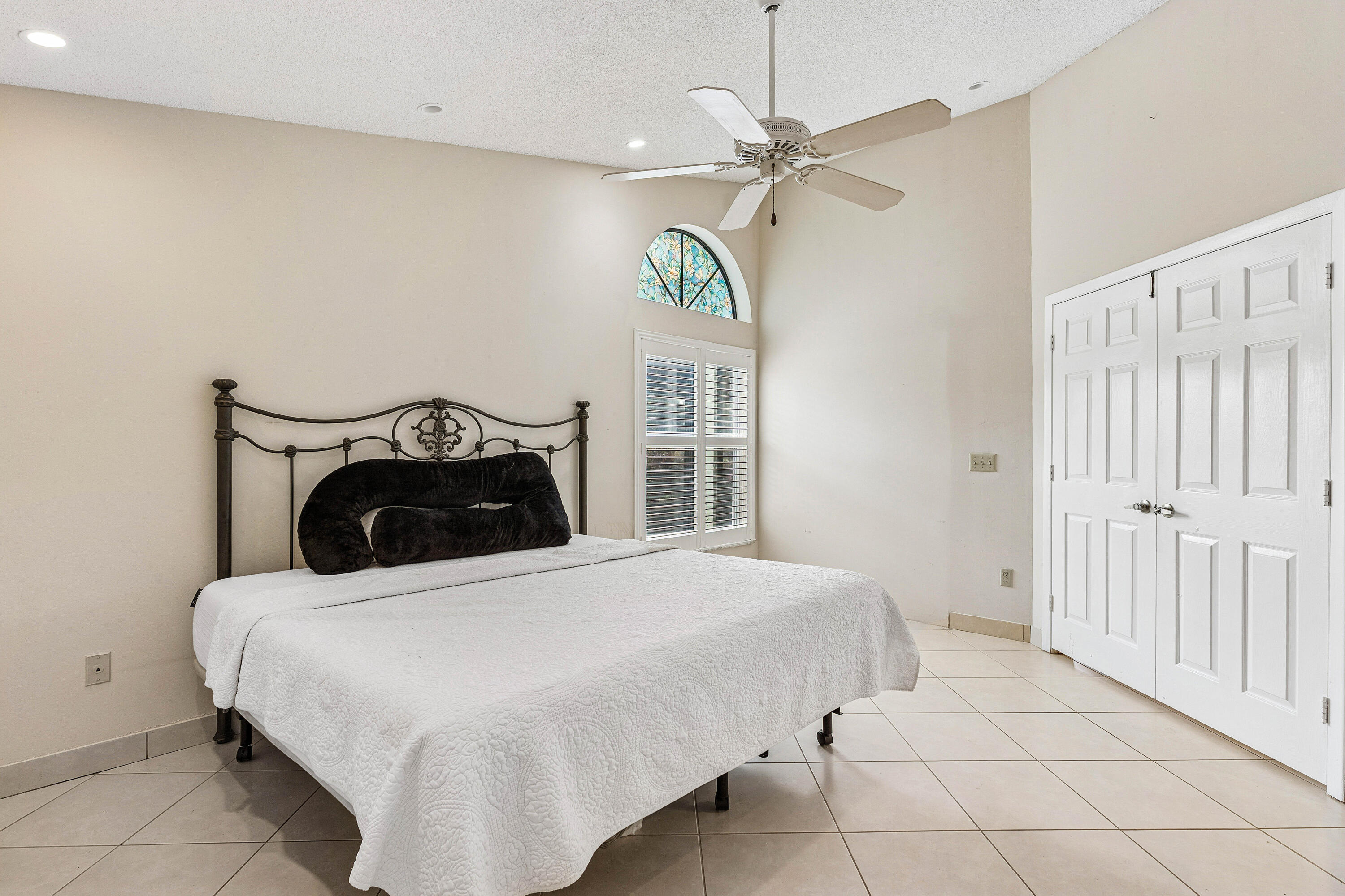 6249 Beaconwood Road Lake Worth, FL 33467 - Photo 19 of 46 a bedroom with a bed and a chandelier