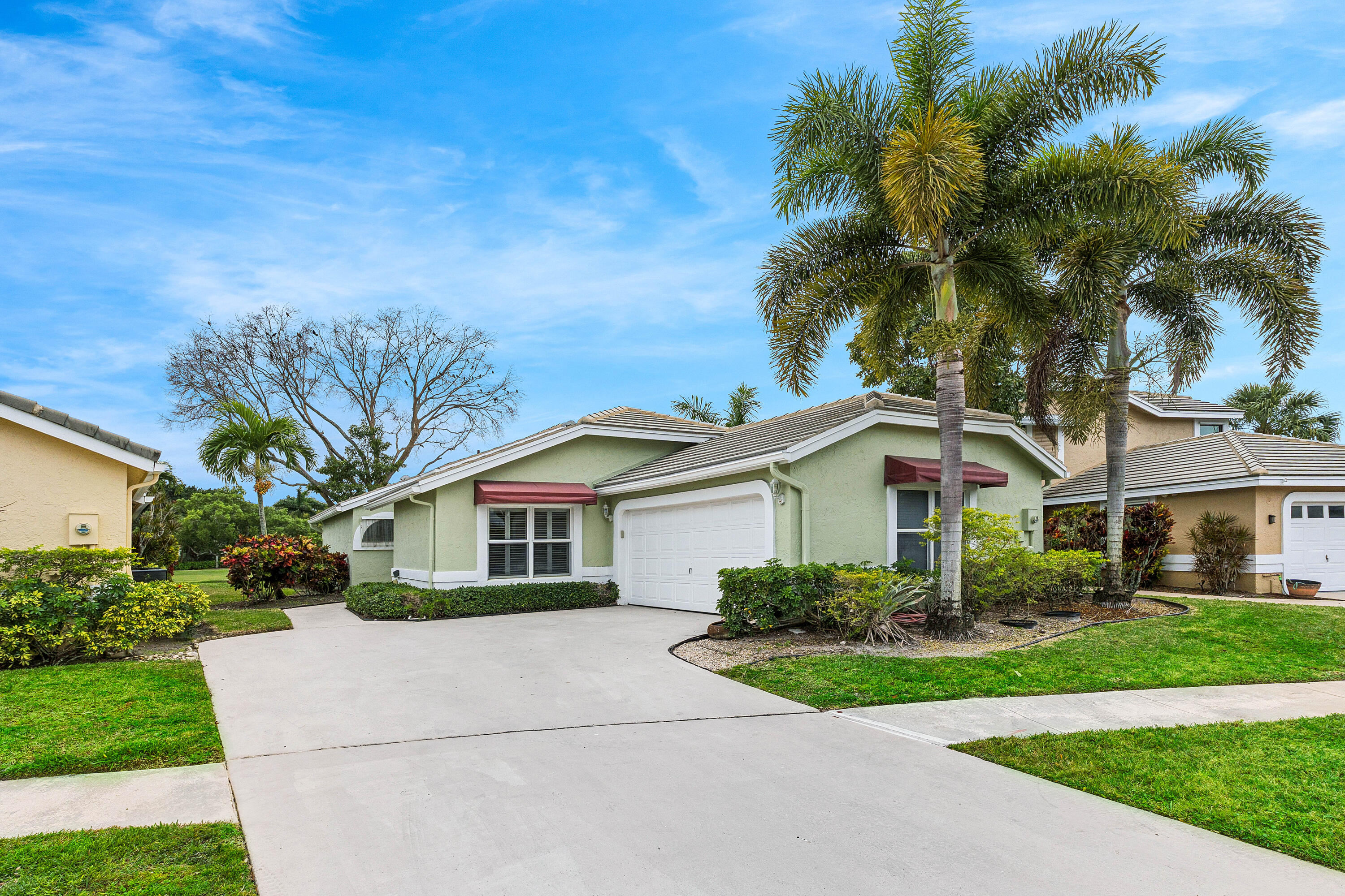 6249 Beaconwood Road Lake Worth, FL 33467 - Photo 2 of 46 a front view of a house with a garden and plants