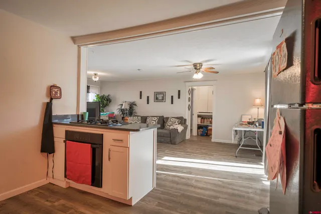 a living room with stainless steel appliances granite countertop furniture and a kitchen view