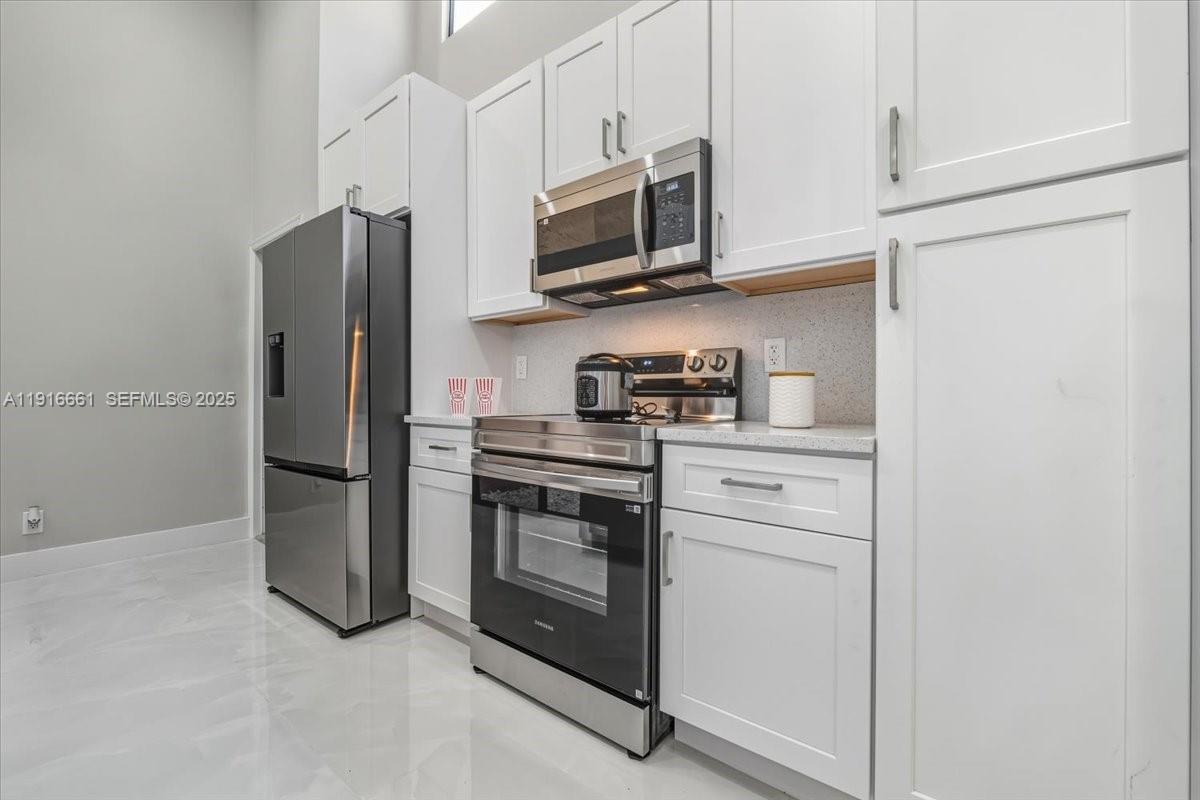 22708 Meridiana Drive Boca Raton, FL 33433 - Photo 15 of 46 a kitchen with stainless steel appliances a refrigerator stove and microwave