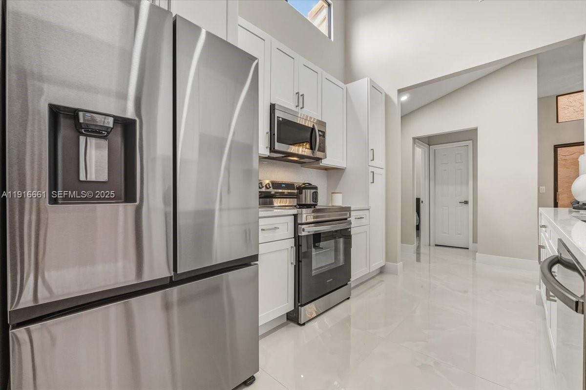 22708 Meridiana Drive Boca Raton, FL 33433 - Photo 19 of 46 a kitchen with stainless steel appliances a refrigerator stove and microwave