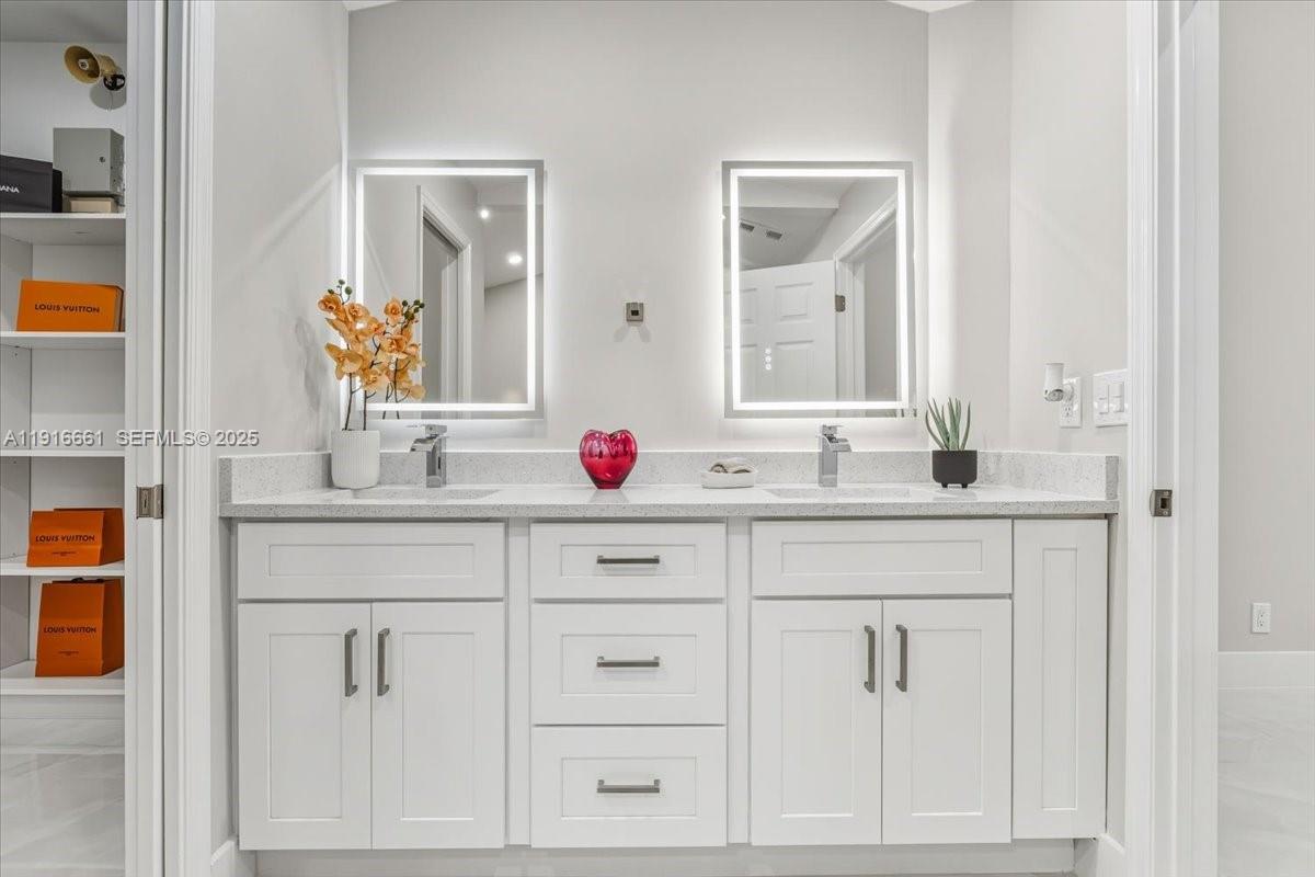 22708 Meridiana Drive Boca Raton, FL 33433 - Photo 26 of 46 a bathroom with white cabinets sink and mirror