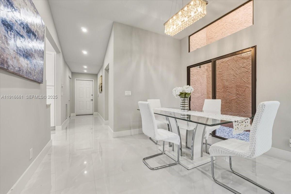 22708 Meridiana Drive Boca Raton, FL 33433 - Photo 7 of 46 a view of a hallway with furniture and chandelier