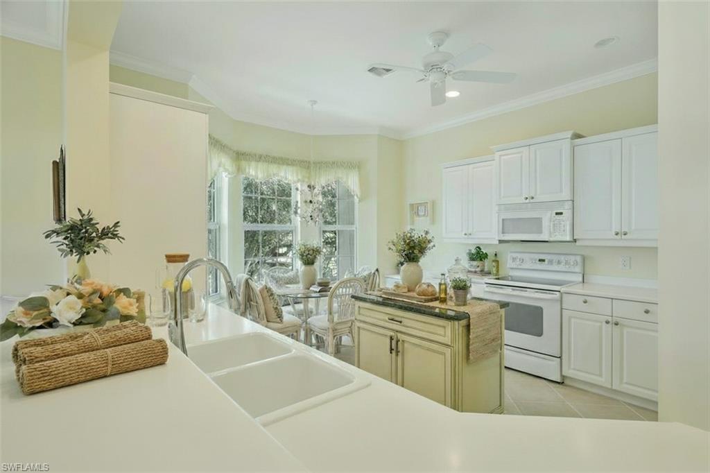 5025 Blauvelt Way, Unit 202 Naples, FL 34105 - Photo 11 of 26 a kitchen with cabinets a sink and white stainless steel appliances