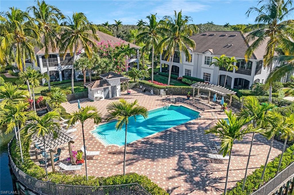 5025 Blauvelt Way, Unit 202 Naples, FL 34105 - Photo 22 of 26 a view of a swimming pool with a patio and a yard