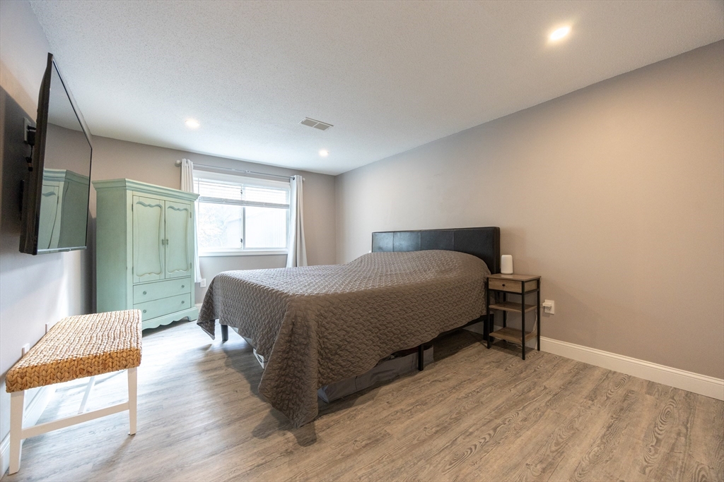 605 Franklin Crossing Road, Unit 605 Franklin, MA 02038 - Photo 11 of 31 a spacious bedroom with a bed and wooden floor