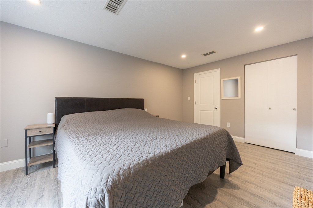 605 Franklin Crossing Road, Unit 605 Franklin, MA 02038 - Photo 14 of 31 a bedroom with a bed and wooden floor