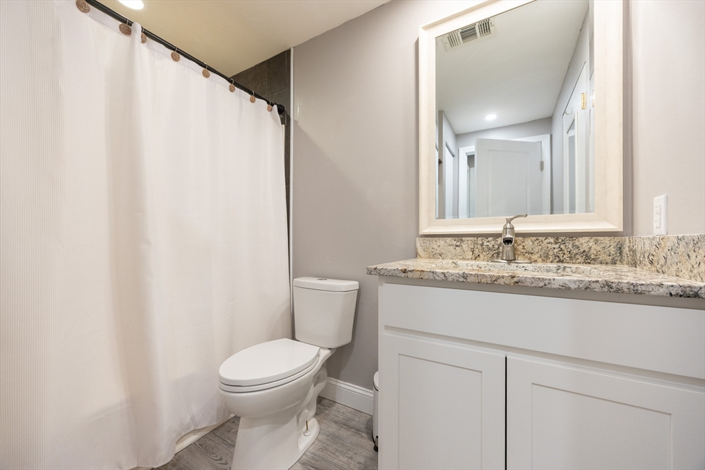 605 Franklin Crossing Road, Unit 605 Franklin, MA 02038 - Photo 20 of 31 a bathroom with a granite countertop sink toilet and a mirror