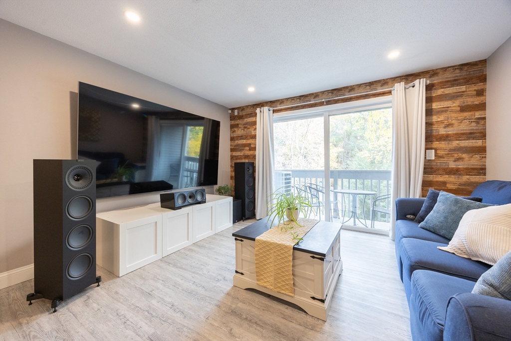 605 Franklin Crossing Road, Unit 605 Franklin, MA 02038 - Photo 2 of 31 a living room with furniture and a flat screen tv