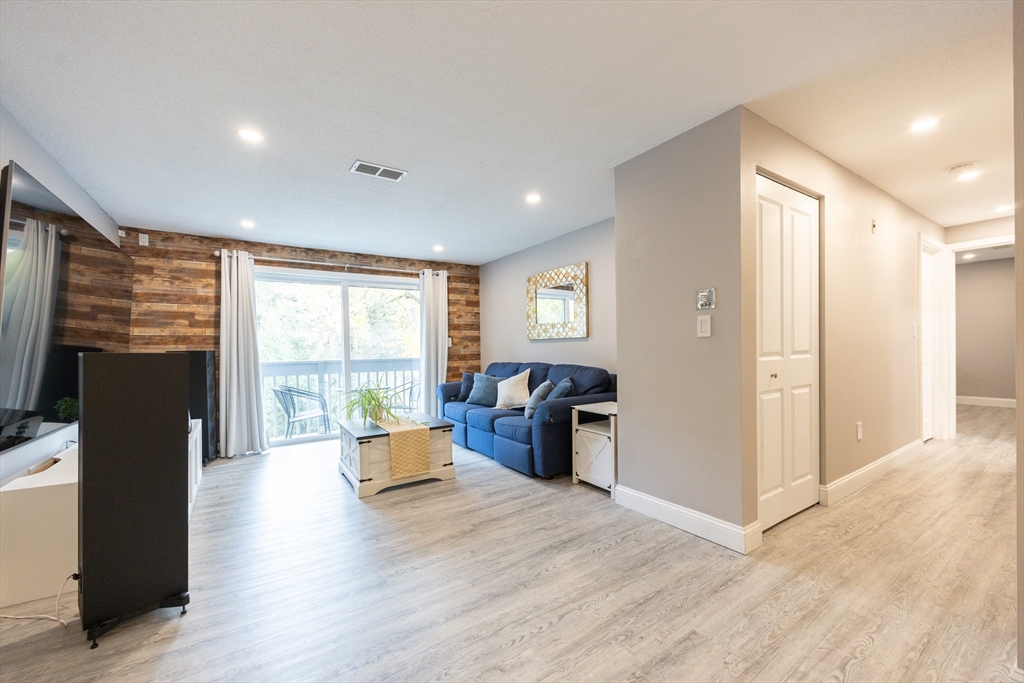 605 Franklin Crossing Road, Unit 605 Franklin, MA 02038 - Photo 3 of 31 a living room with furniture and a flat screen tv