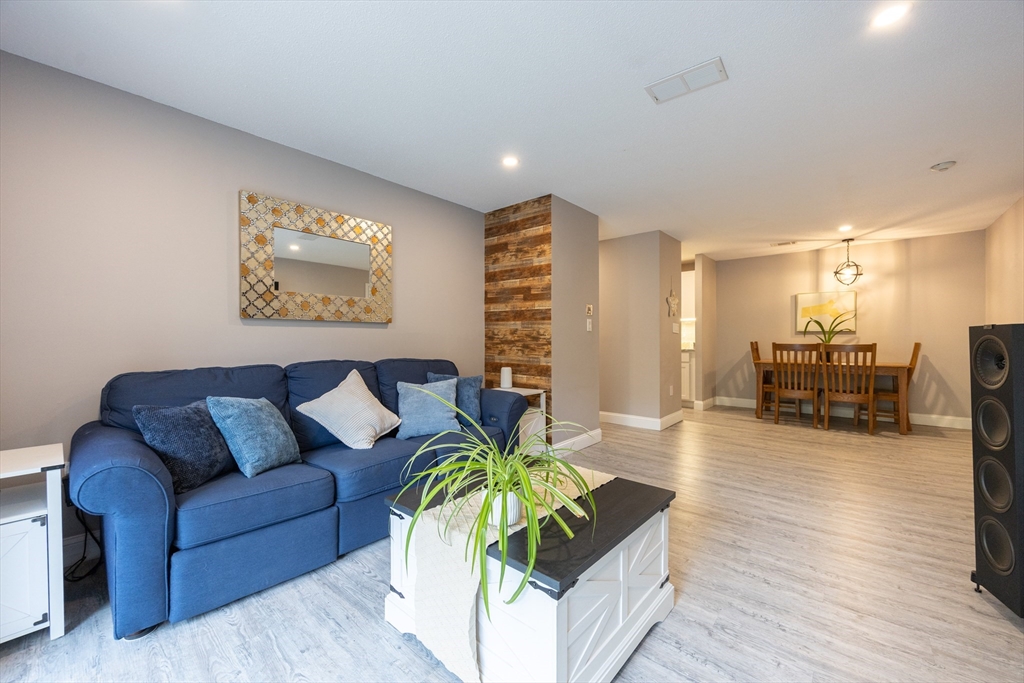 605 Franklin Crossing Road, Unit 605 Franklin, MA 02038 - Photo 4 of 31 a living room with furniture and a wooden floor