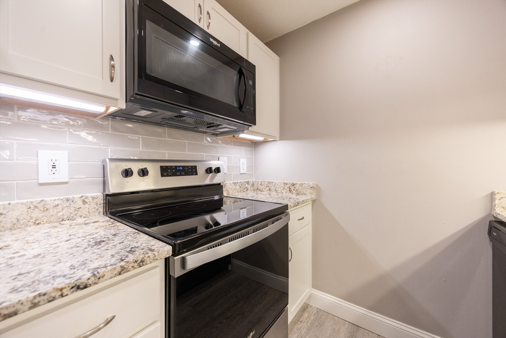 605 Franklin Crossing Road, Unit 605 Franklin, MA 02038 - Photo 10 of 31 a kitchen with a stove and a microwave