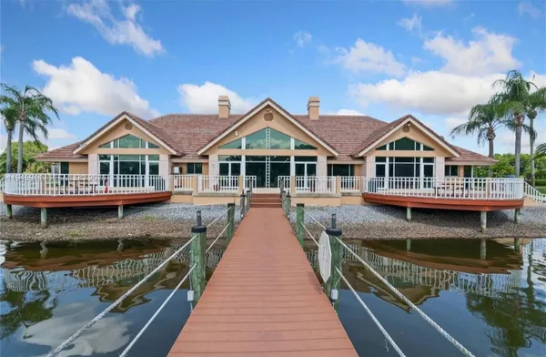 a dining room with wooden floor furniture and a chandelier