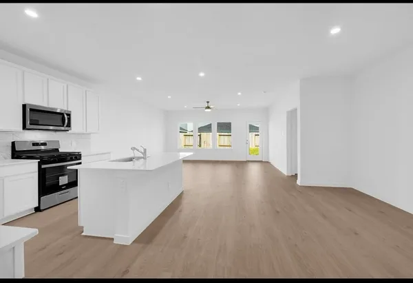 a large kitchen with a sink and a stove top oven