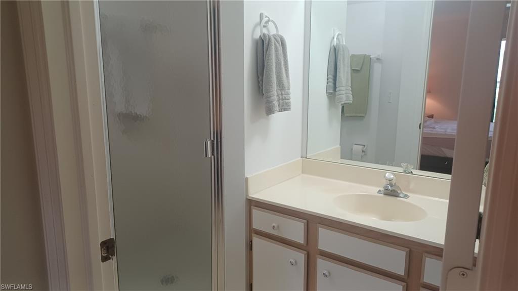 716 Landover Circle, Unit 102 Naples, FL 34104 - Photo 11 of 31 a bathroom with a sink and a mirror