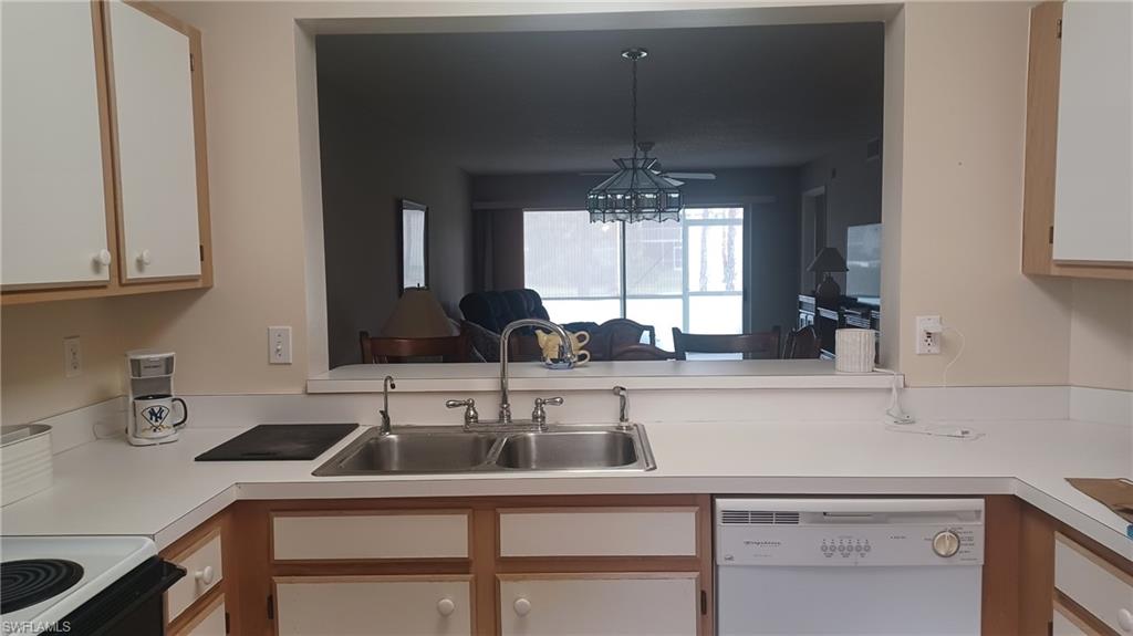 716 Landover Circle, Unit 102 Naples, FL 34104 - Photo 17 of 31 a kitchen with a sink and cabinets