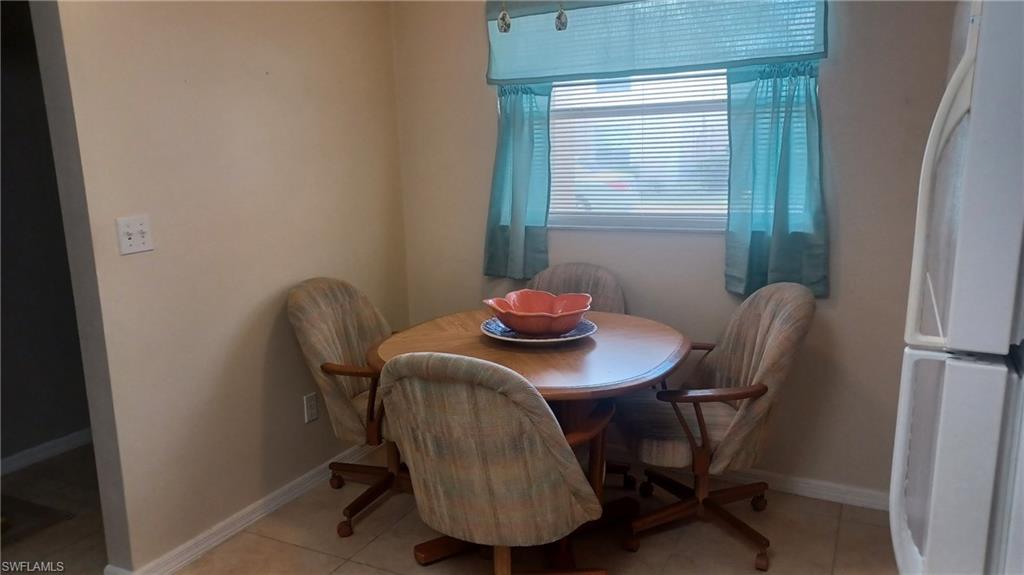 716 Landover Circle, Unit 102 Naples, FL 34104 - Photo 22 of 31 a view of a dining room with furniture and window