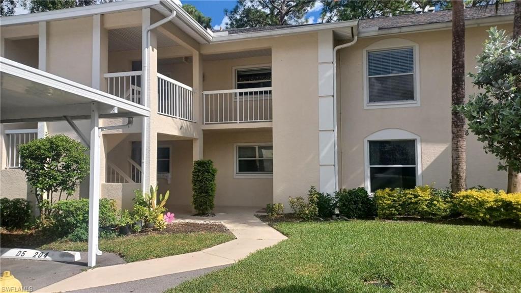 716 Landover Circle, Unit 102 Naples, FL 34104 - Photo 24 of 31 a front view of a house with garden