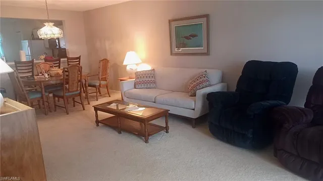 a living room with furniture a dining table and a chandelier