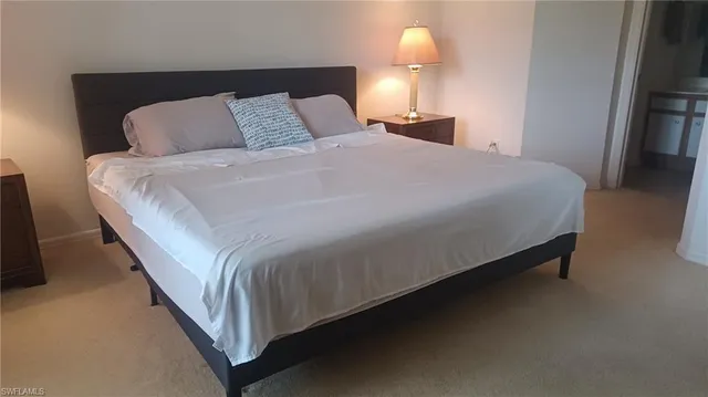 a bed sitting in a bedroom next to a lamp