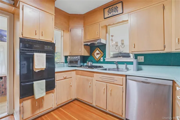 a kitchen with stainless steel appliances granite countertop a sink and cabinets with wooden floor