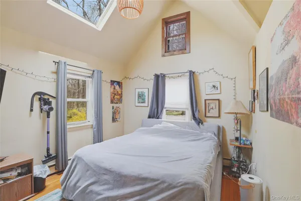 a bedroom with a bed and a flat tv screen on the dresser