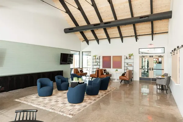 a living room with furniture a flat screen tv and a window