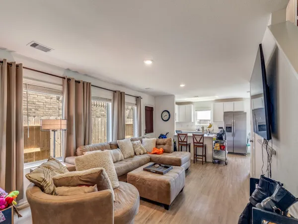 a living room with furniture flat screen tv and large window