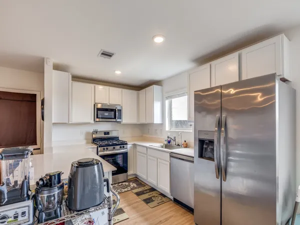 a kitchen with kitchen island a counter top space stainless steel appliances and cabinets