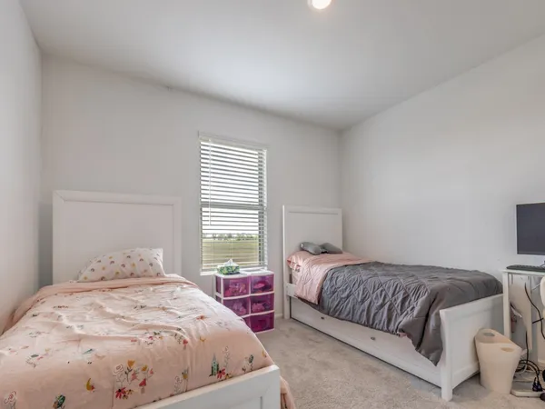 a bedroom with two beds and a large window