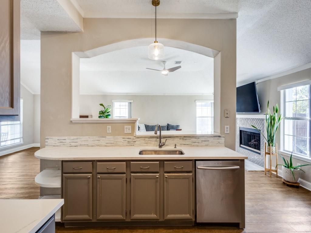 7129 Sample Drive The Colony, TX 75056 - Photo 25 of 25 Kitchen featuring open floor plan, stainless steel dishwasher, dark wood finished floors, a ceiling fan, and crown molding