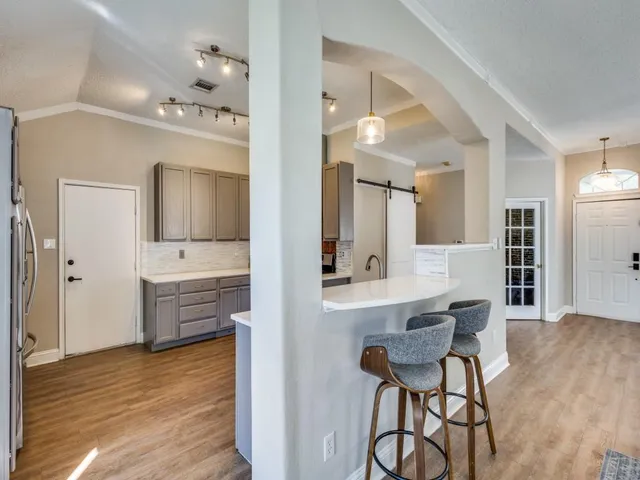 a kitchen with a sink cabinets and wooden floor