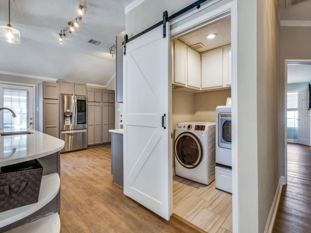 7129 Sample Drive The Colony, TX 75056 - Photo 16 of 25 Laundry room with healthy amount of natural light, a textured ceiling, lofted ceiling, washer and dryer, and light wood-type flooring