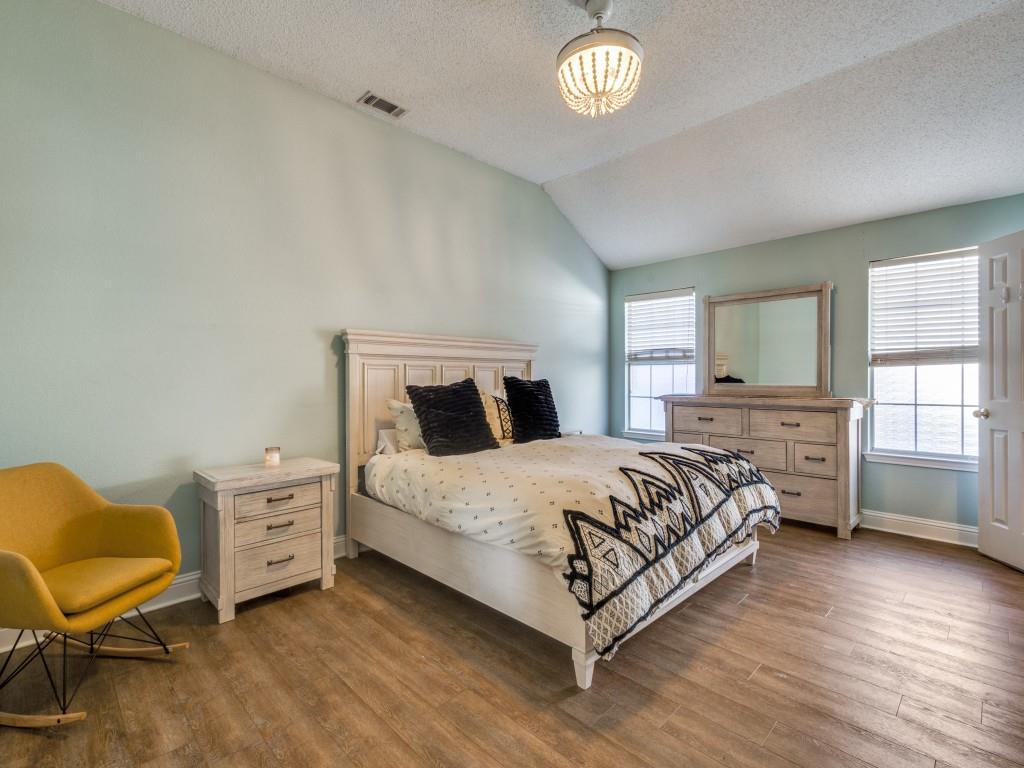 7129 Sample Drive The Colony, TX 75056 - Photo 17 of 25 Bedroom with vaulted ceiling, a textured ceiling, and wood finished floors