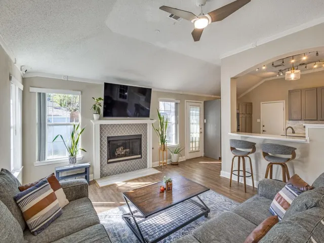a living room with furniture a flat screen tv and a fireplace