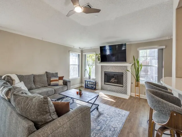 a living room with furniture a flat screen tv and a fireplace