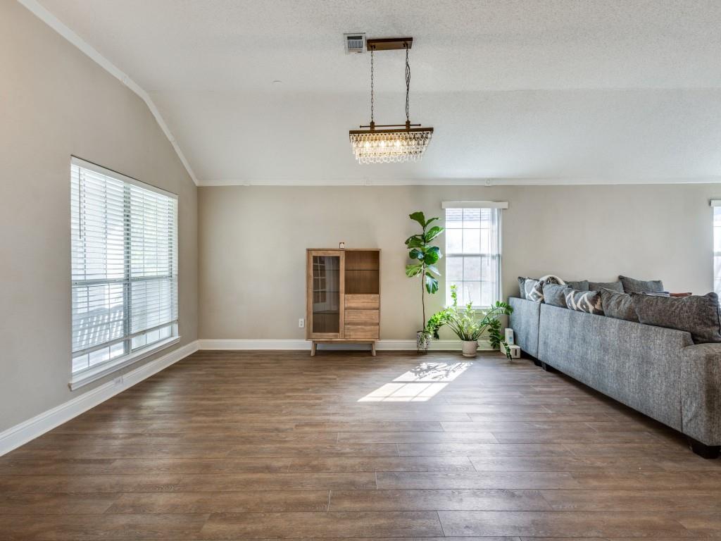 7129 Sample Drive The Colony, TX 75056 - Photo 8 of 25 Living room featuring dark wood finished floors, vaulted ceiling, and ornamental molding