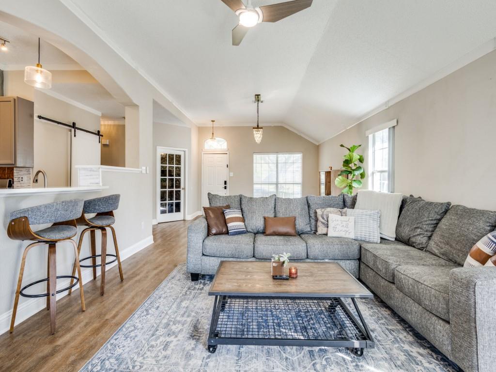 7129 Sample Drive The Colony, TX 75056 - Photo 10 of 25 Living area featuring a barn door, lofted ceiling, arched walkways, light wood-style floors, and a ceiling fan