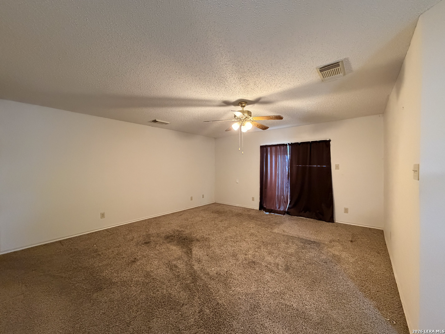 8349 Morning Grove Converse, TX 78109 - Photo 2 of 27 an empty room with a chandelier fan and windows