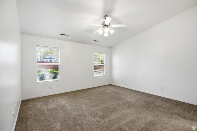 1630 East 2450th Street South, Unit 263 St. George, UT 84790 - Photo 14 of 24 Spacious room featuring neutral carpet flooring, a vaulted ceiling, and two windows with blinds