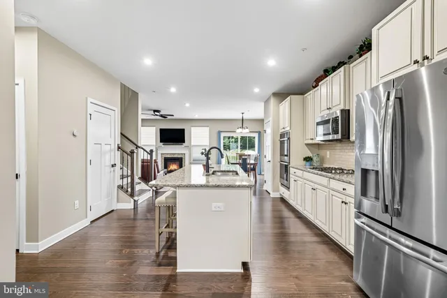 a kitchen with stainless steel appliances granite countertop a refrigerator and a stove top oven