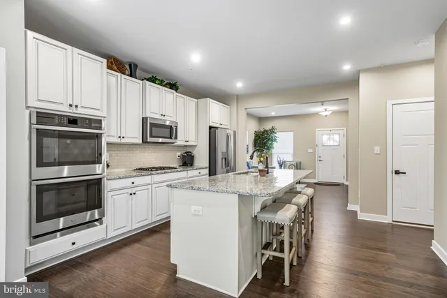 a kitchen with stainless steel appliances kitchen island granite countertop a stove and a refrigerator