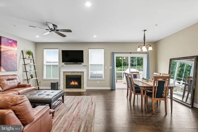 a living room with fireplace furniture and a large window