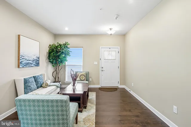 a living room with furniture wooden floor and a potted plant