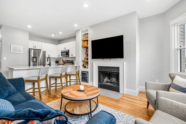 a living room with furniture a flat screen tv and a fireplace
