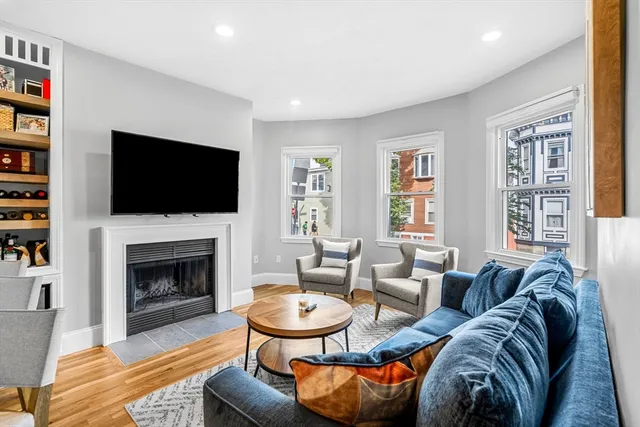 a living room with furniture a flat screen tv and a fireplace